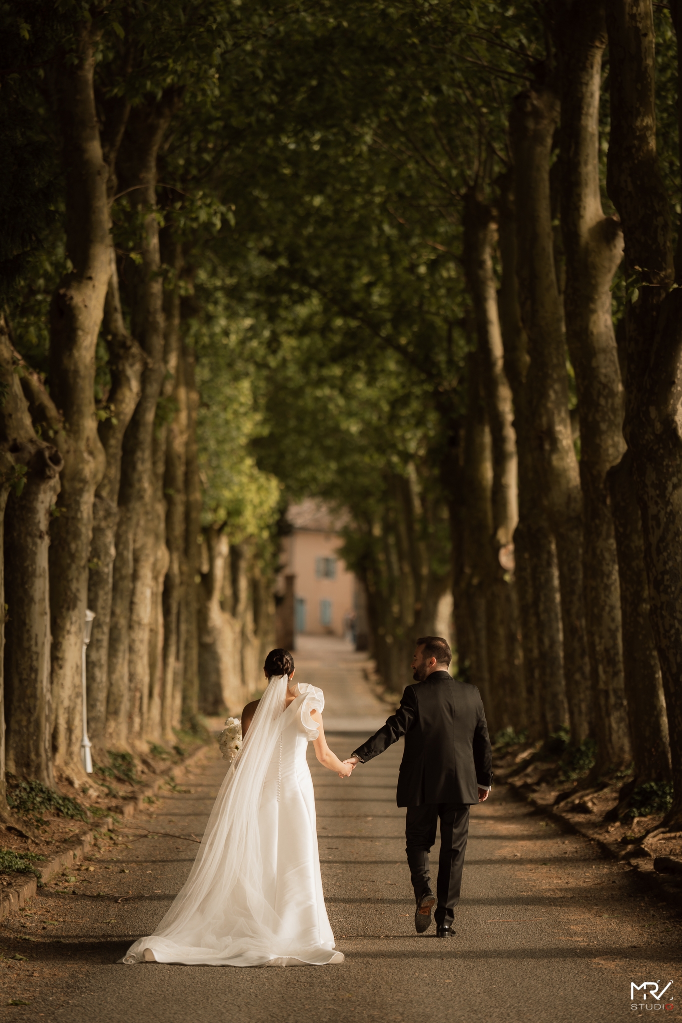 Photographe Mariage à Lyon - MRV Studio Photo | Votre Histoire en Images Couple de mariés le long de l'entrée du Château des Ravatys